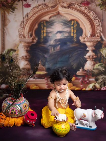This little Krishna is ready to dig into his pot of butter. The rich, palace-themed backdrop adds a grand feel to the Janmashtami session.