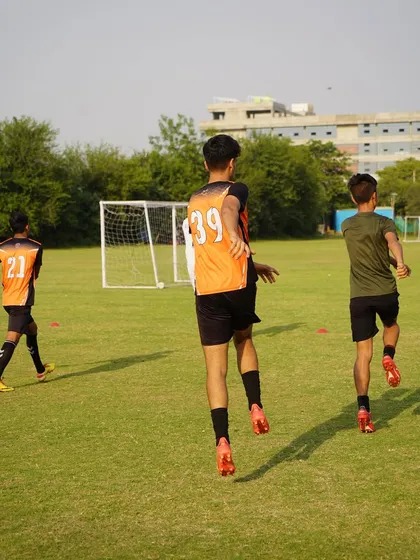 Players performing high-knees and other dynamic movements to prepare for the session.