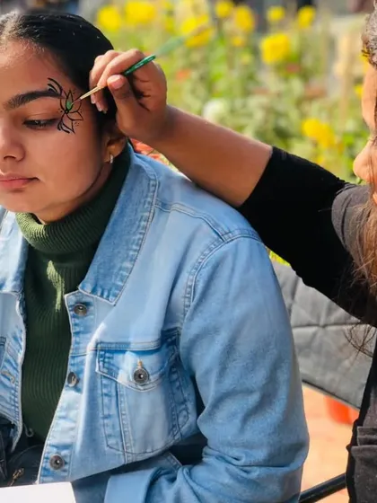 Here's a glimpse of me in my element. I love the process of creating custom art for each person, like this intricate spider design. I bring my full mobile setup to every event, ensuring a professional and enjoyable experience.
