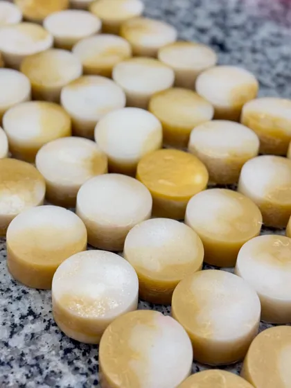 A close-up of the custom champa-scented loofah soaps. The golden hue and smooth texture make them a beautiful and practical party favor.