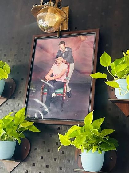 A simple yet beautiful way to honor loved ones. These four neon pothos plants on small wall shelves frame a family picture, adding a touch of living memory and vibrant color to the wall.