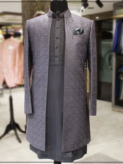 A layered Indo-Western look featuring a grey patterned jacket over a dark kurta. This is a stylish and sophisticated option for a Sangeet or reception.