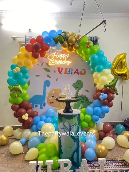 Another angle of the dinosaur party, showing the full balloon ring and the light-up name sign. The mix of colors makes it very vibrant.