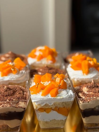 An assortment of our popular mousse cups. This photo features our Tiramisu, Mango Vanilla, and Chocolate Mousse cups, perfect for a party dessert table.