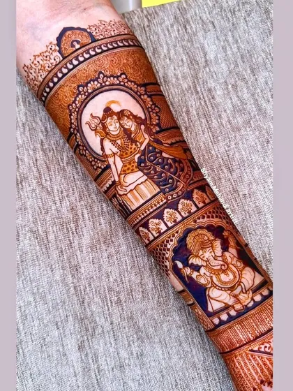 A stunning forearm piece featuring portraits of Lord Shiva, Parvati, and Ganesha, perfect for a devotional bridal theme.