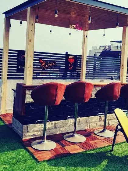 The same bar counter during the day, showing the natural stone base and the comfortable bar stools, ready for guests.