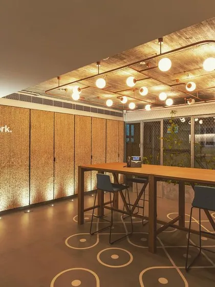 Light can transform simple materials. For this collaborative space, I used grazers to cast light down the textured wall, revealing its rich detail and creating a sense of warmth. Above, a custom grid of globe lights provides soft ambient illumination, making the space feel welcoming and inspiring.