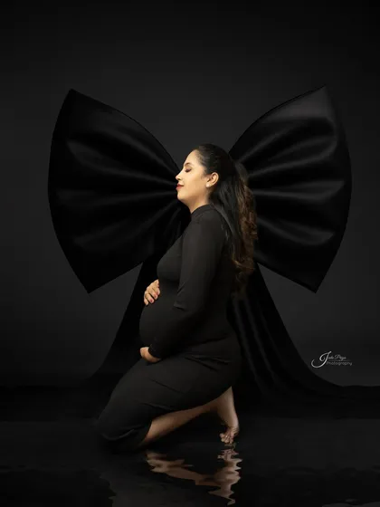 This is an example of my fine art maternity style, using dramatic lighting and a simple black gown. The focus is entirely on the mother's silhouette, creating a powerful and elegant portrait.