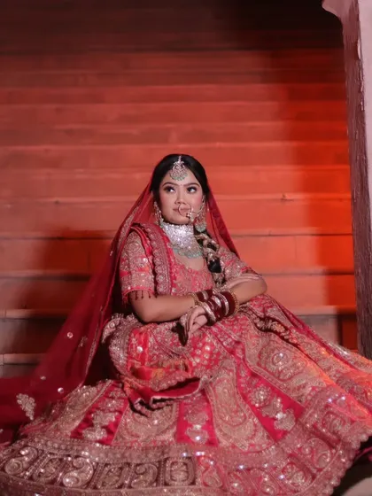 A wider shot showing the full spread of the red bridal lehenga against the architectural steps.