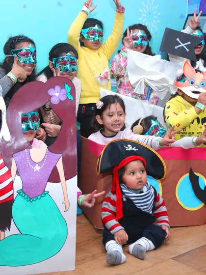 A pirate and mermaid adventure. Kids are dressed up with masks and hats, posing with themed cutouts for a fun photo opportunity.