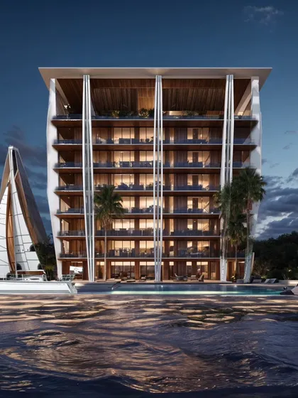 The Koh Lanta project at night. The lighting design highlights the building's unique form, which is inspired by the coastal landscape. The property is designed to feel like a relaxed, contemporary resort.