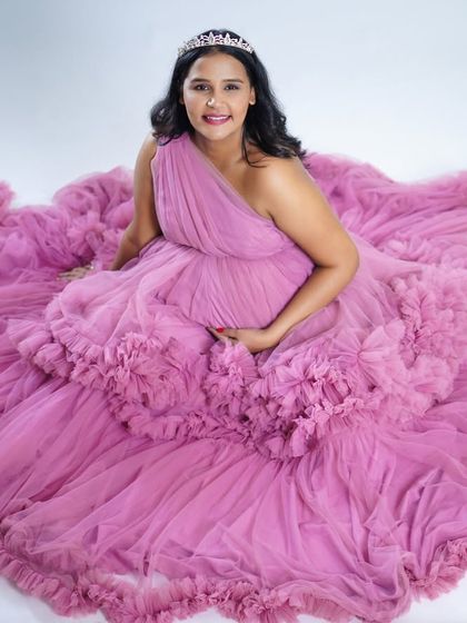 A lovely seated portrait of the mother-to-be enveloped in the soft ruffles of our pink gown. The tiara adds a touch of royalty to this beautiful pregnancy photo.