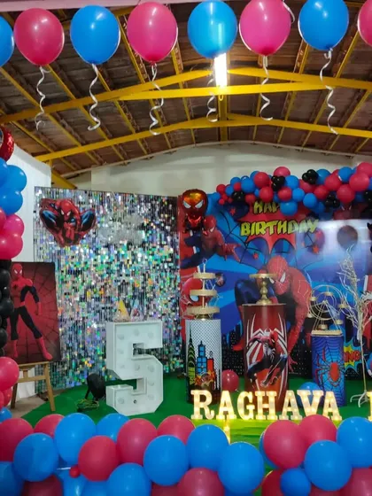 An elaborate Spiderman party with a sequin backdrop and extensive balloon decorations covering the floor and ceiling.