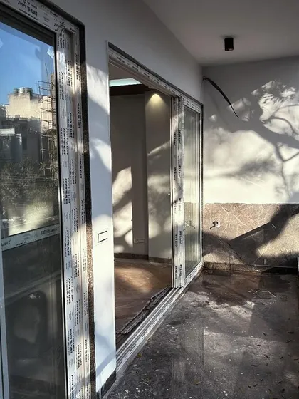 The balcony of the CR Park residence, showcasing the finished marble flooring and large sliding glass doors. We design balconies to be functional extensions of the living space, maximizing light and air.