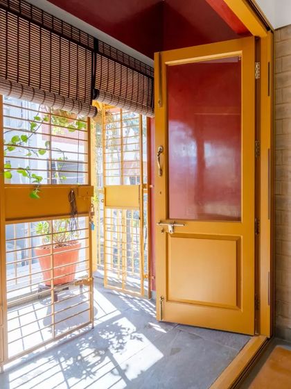A detail of a doorway leading to a small balcony, showing how even small spaces are designed to bring in light and air.