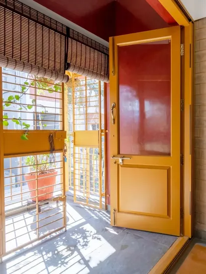 A detail of a doorway leading to a small balcony, showing how even small spaces are designed to bring in light and air.