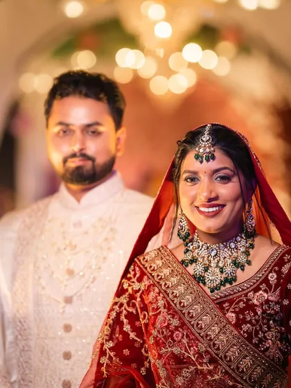 A beautiful portrait of the bride and groom. Her makeup looks radiant against the warm lighting of the venue.