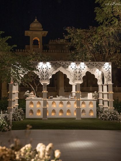 The grand bar structure illuminated at night, showcasing its intricate design and creating a beacon of celebration.