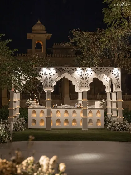 The grand bar structure illuminated at night, showcasing its intricate design and creating a beacon of celebration.