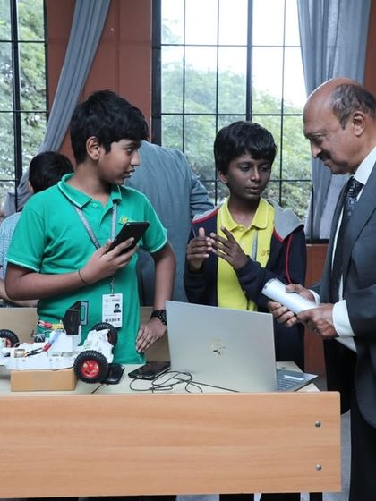 Two students present their self-made, remote-controlled vehicle. This project required them to master mechanical design, motor control, and wireless communication to bring their concept to life.