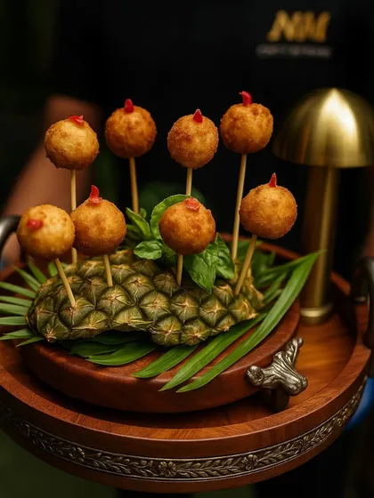 Golden bites of indulgence. Our handcrafted cheese croquettes are served with style on a crown of pineapple, creating a visually stunning presentation that is as premium as the taste.