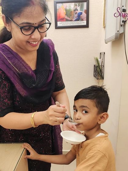 Administering Suvarnaprashan drops, which are a blend of purified gold ash and medicinal herbs. This is a safe and effective way to build a strong foundation for a child's health from an early age.