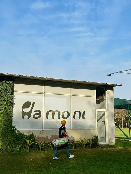 A golfer walks past our iconic logo on the side of the Fitting Studio building.