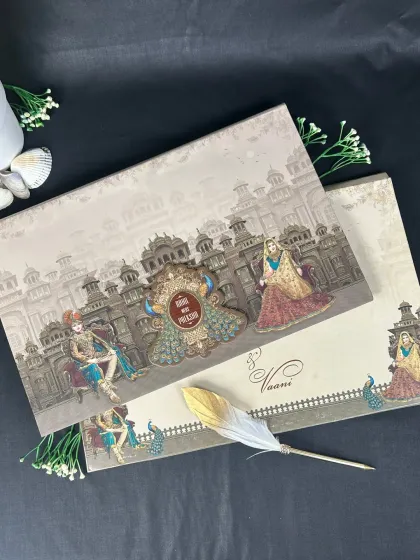 This invitation suite showcases a grand palace facade, with intricate 3D elements and peacock motifs framing the couple's names.