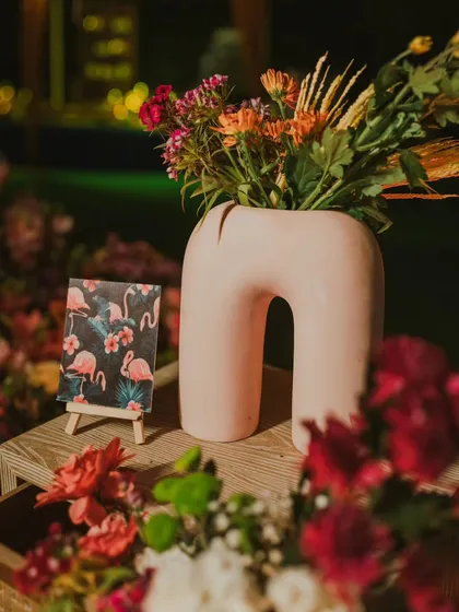 A pop of personality with a flamingo-themed art card, paired with a contemporary pink vase and a burst of colourful flowers. These small touches add character to the cocktail decor.
