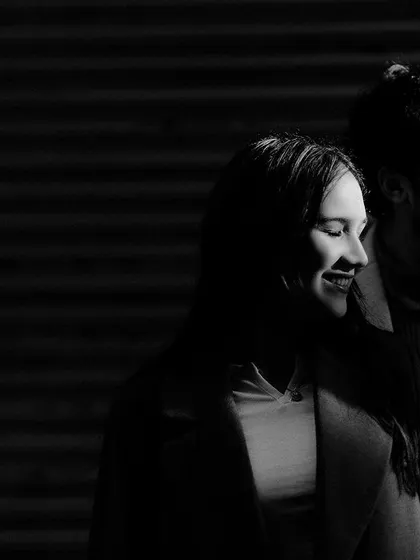 A dramatic black and white portrait using strong light and shadow. This artistic shot from a Delhi pre-wedding session creates a moody and intimate feel.