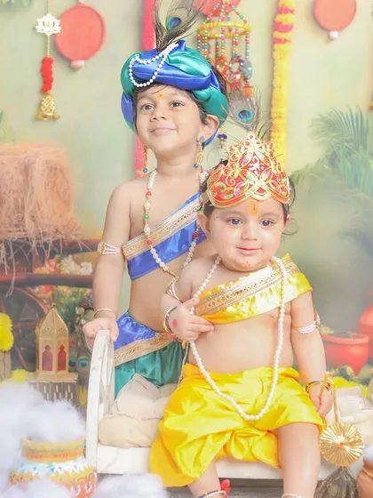 Krishna and Balram together. This sibling photoshoot captures the divine duo with a beautifully detailed backdrop.