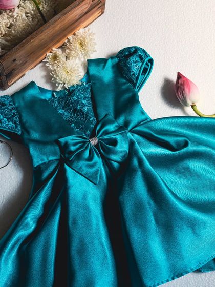 This peacock blue satin dress is a true jewel. The rich color, combined with intricate sequin and lace detailing on the bodice, makes it an exceptionally elegant choice for a formal celebration.