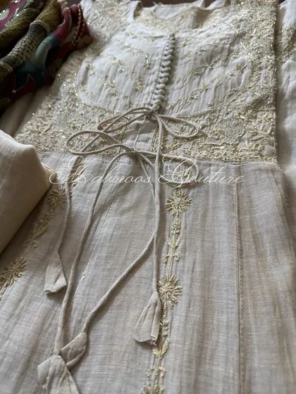 A close-up on the waist of the Achkan Anarkali, detailing the delicate tie-up with tassels and the intricate embroidery on the bodice.