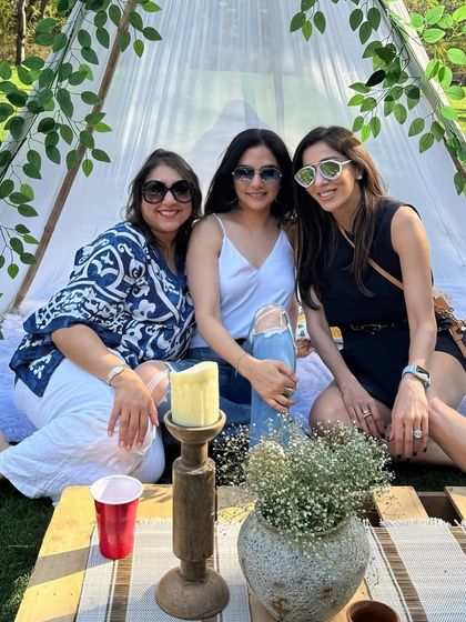 Guests enjoying the cozy teepee at our outdoor picnic event. These elements add a fun, whimsical touch and provide a great spot for photos.