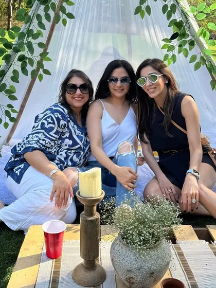 Guests enjoying the cozy teepee at our outdoor picnic event. These elements add a fun, whimsical touch and provide a great spot for photos.
