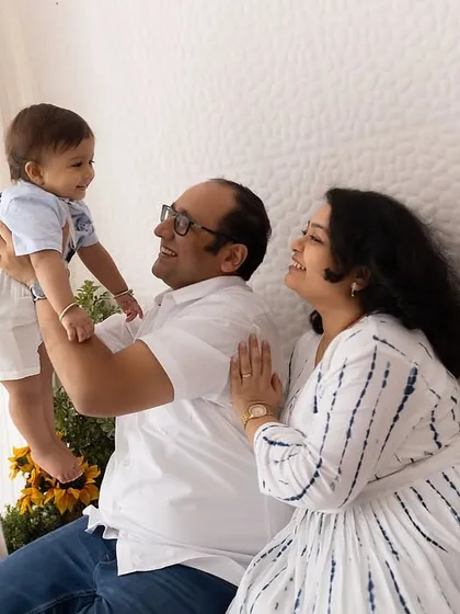 Lifting him high! A playful and joyous moment between parents and their baby boy in the studio.