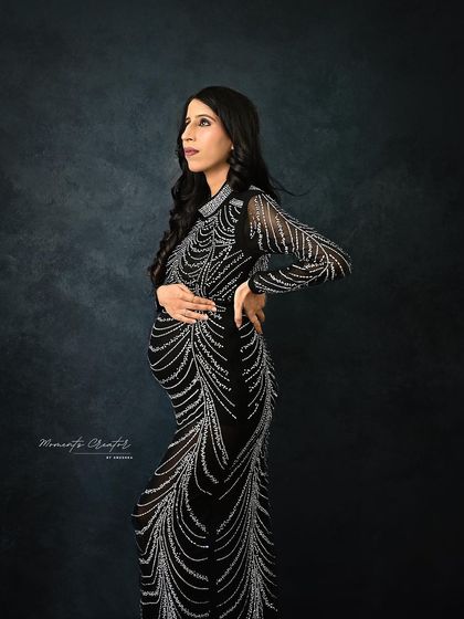 A glamorous full-body portrait. The intricate silver beading on the black gown shimmers, creating a sophisticated and high-fashion look.