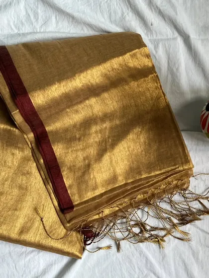 Our 'Aarini' tissue cotton saree in a beautiful gold with a maroon border. The saree comes with a running blouse, but we love styling our sarees with contrast blouses for a different look.