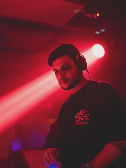 A moody shot of me under a single red spotlight, focused on the music.