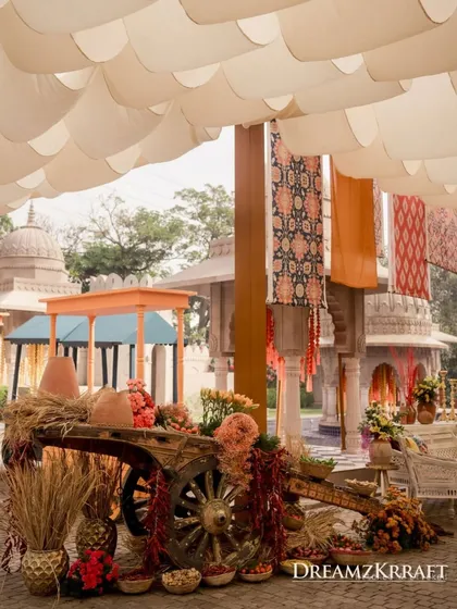 A Mehendi inspired by a traditional Soukh Bazaar, featuring a rustic cart decorated with earthen pots and vibrant textiles, perfectly capturing the market theme.