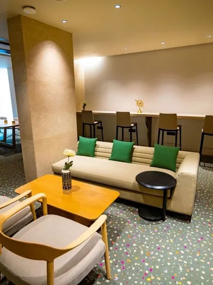 This lounge area adjacent to the business center offers a semi-formal setting for meetings or relaxation. The design uses comfortable sofas, modern chairs, and colorful accents to create a versatile space that bridges work and leisure.