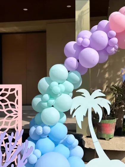 A closer look at the organic balloon garland for the entrance arch. I used a gradient of pastel colours from blue to mint, lilac, and pink, accented with themed cutouts to create a beautiful flow.