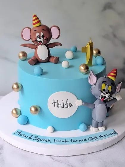 One year of fun and chaos, just like Tom & Jerry! This first birthday cake features handcrafted, detailed figures of the classic cartoon duo, ready for their next adventure.