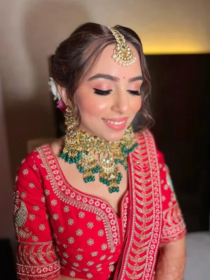 Akshita's vision for her bridal look came to life perfectly. A soft pink eyeshadow and glowing skin to complement her traditional red lehenga.