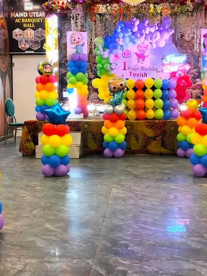 The full Cocomelon birthday setup, showing how the rainbow balloon pillars and stage decor create a vibrant and exciting party atmosphere.