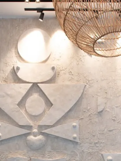 A close-up of a custom-designed, three-dimensional geometric art wall. The raw, textured concrete finish and abstract shapes create a powerful focal point.