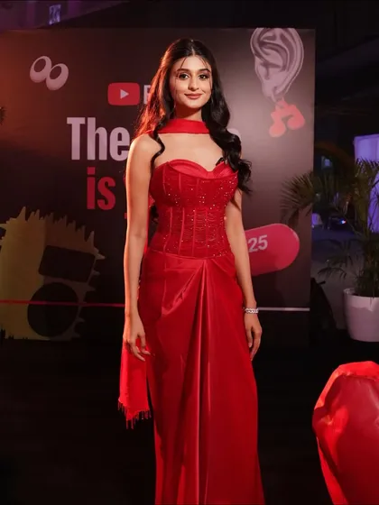 The full red carpet look. Payal's red ensemble is perfectly complemented by her romantic curls and flawless makeup, making her presence unforgettable.