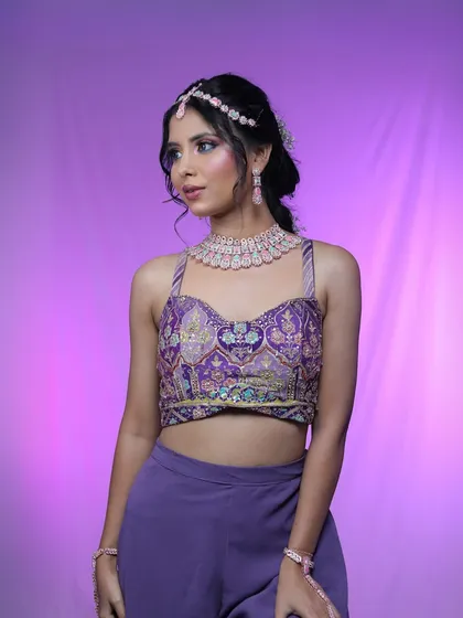 A full shot of the model in a purple co-ord set, highlighting the complete glam look.