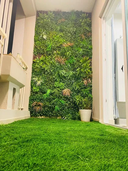 This installation shows how a vertical garden can make a narrow utility balcony feel like a deliberate design feature. The green wall adds life and color, complemented by a clean artificial turf floor.
