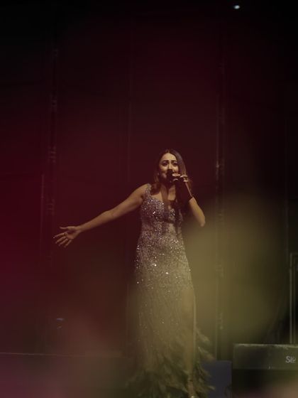A dramatic shot of me on stage during a reception. I am completely in my element under the spotlights, ensuring your event has a commanding and charismatic host.